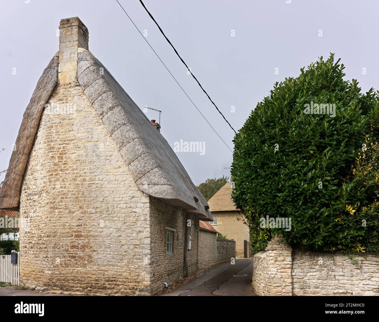 Une maison en pierre au toit de chaume dans le village anglais de Wadenhoe, Northamptonshire, Angleterre. Banque D'Images