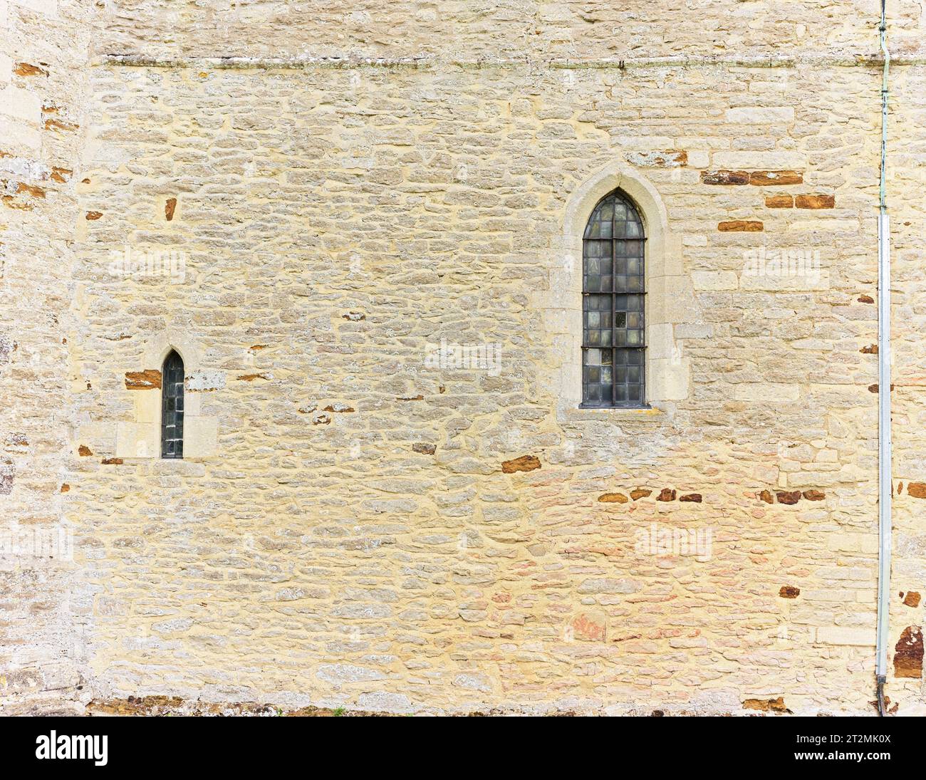 Datant du XIIe siècle, l'église chrétienne de St Michael et tous les Anges avec une petite fenêtre et une fenêtre encore plus petite, Wadenhoe, Angleterre. Banque D'Images