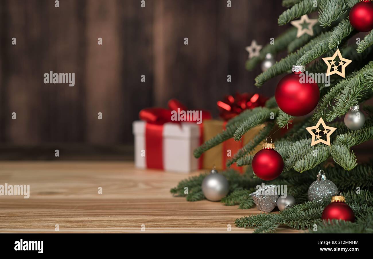 Arbre de Noël avec ornements, boîtes-cadeaux et mur en bois sombre comme copie-espace en arrière-plan Banque D'Images
