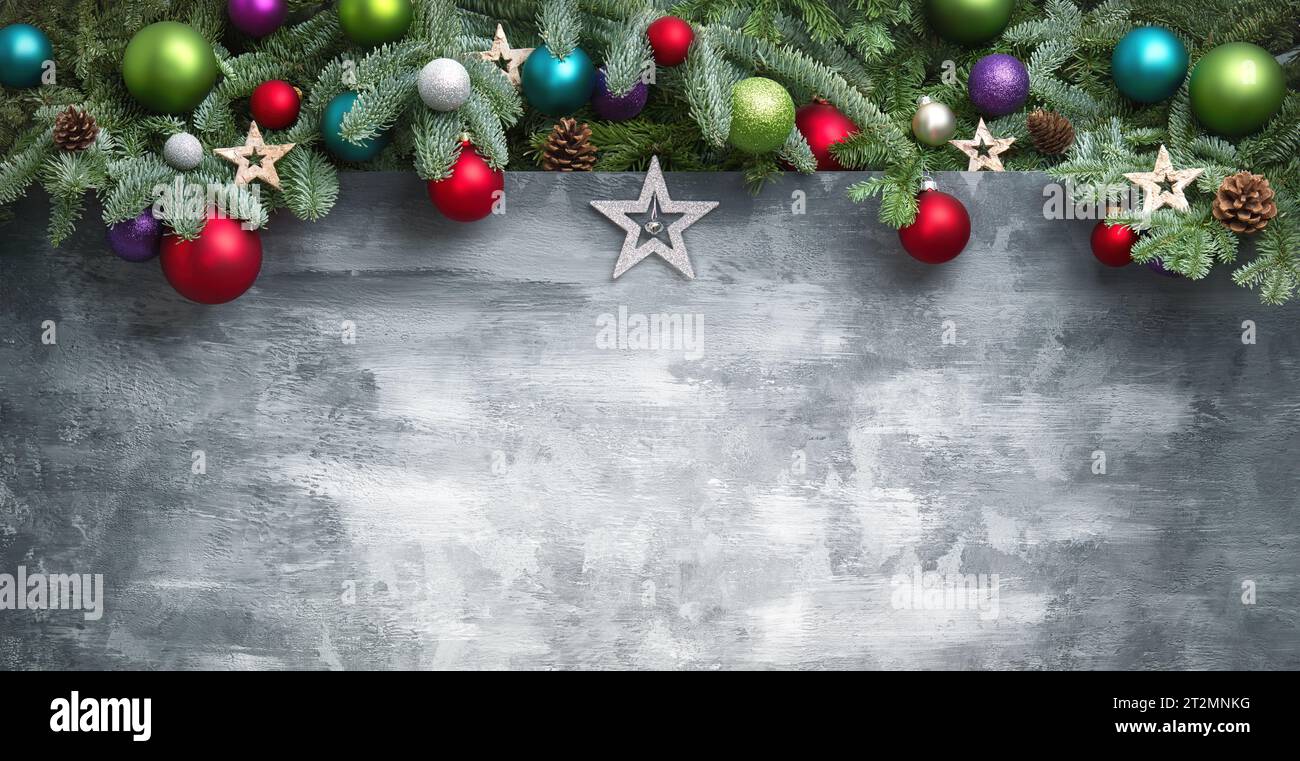Fond de Noël moderne avec une bordure en forme d'arc composée de branches de sapin, boules colorées et étoiles, sur la surface texturée grise faite à la main comme cop Banque D'Images
