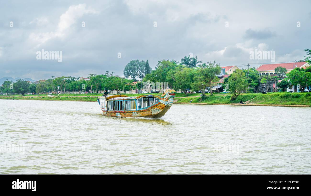 Hue, Vietnam, 17 novembre 2022 : un bateau d'excursion traditionnel en forme de dragon navigue le long de la rivière des parfums à Hue, au centre du Vietnam Banque D'Images