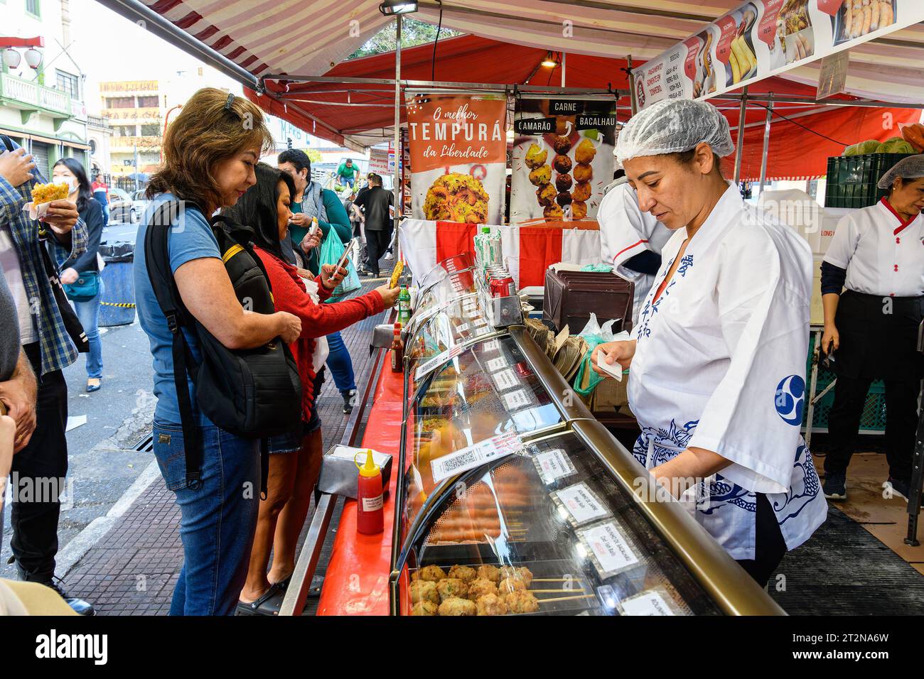 Sao Paulo, SP, Brésil - 08 juin 2023 : les gens achètent de la nourriture sur un stand de la place Liberdade. Destination touristique de Sao Paulo. Banque D'Images