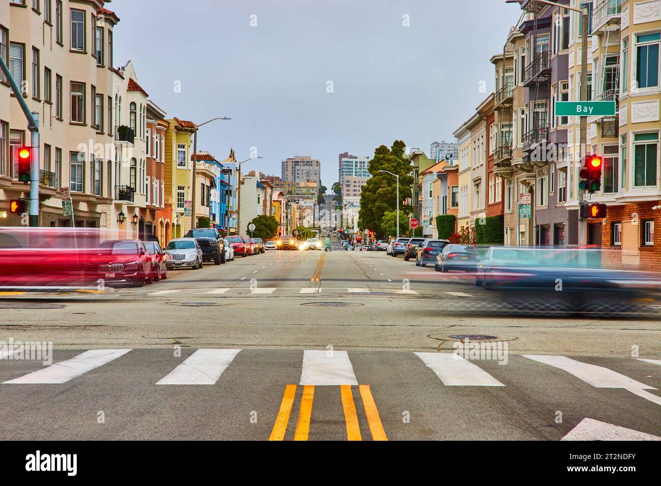 Flou de mouvement des véhicules en mouvement à travers l'intersection de San Francisco avec des lumières et une longue route Banque D'Images