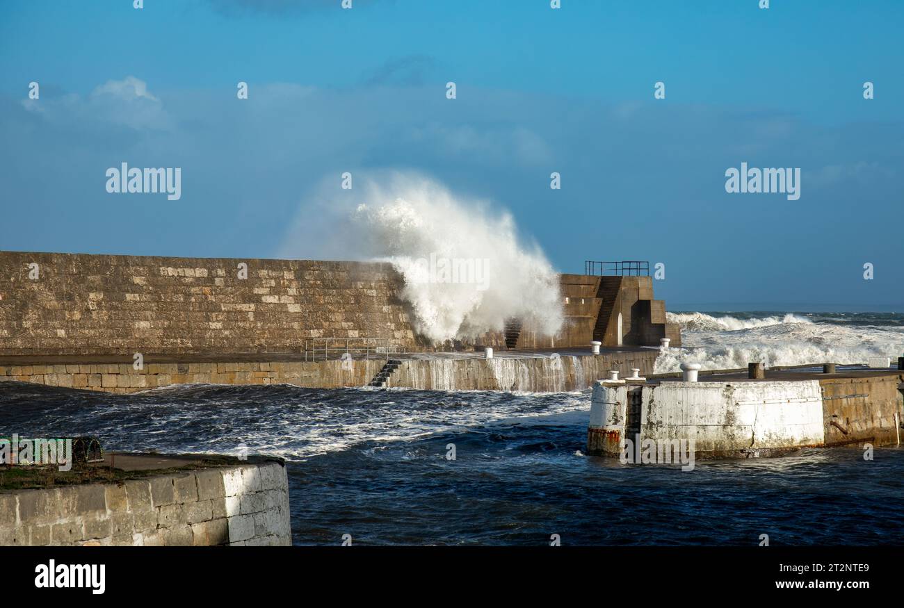 Des vagues qui s'écrasent sur un mur du port pendant la tempête Babet Banque D'Images