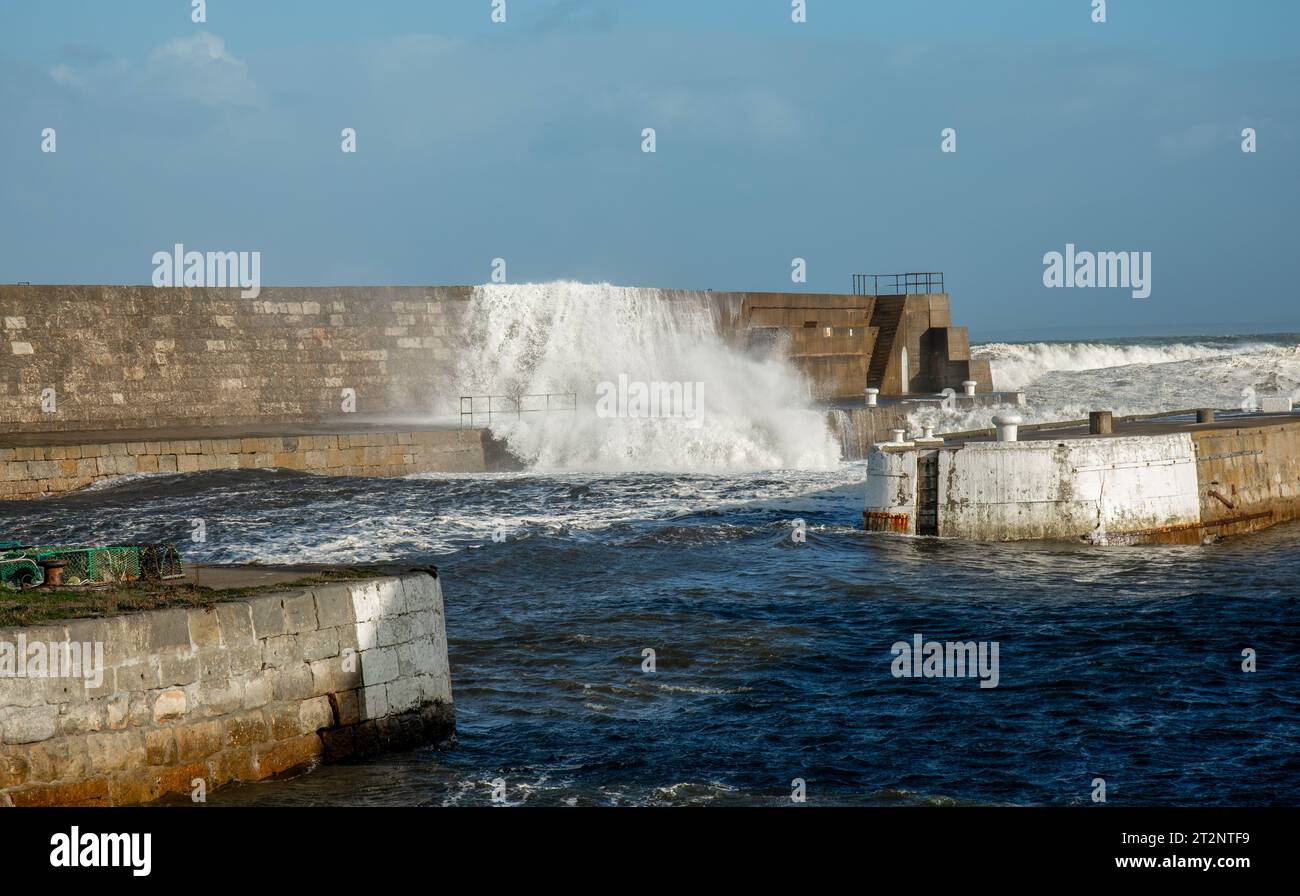 Des vagues qui s'écrasent sur un mur du port pendant la tempête Babet Banque D'Images