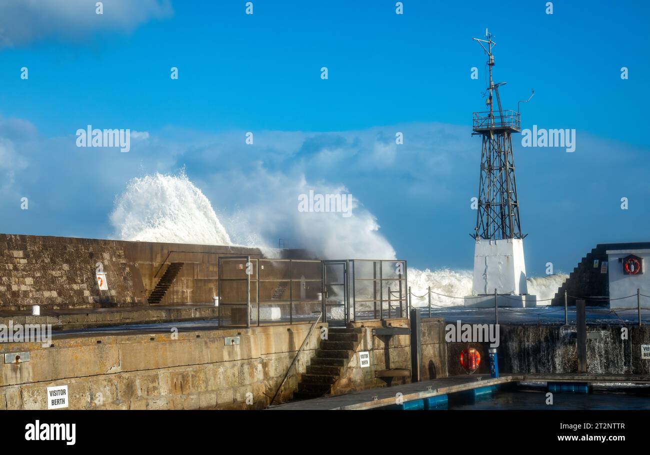 Des vagues qui s'écrasent sur un mur du port pendant la tempête Babet Banque D'Images