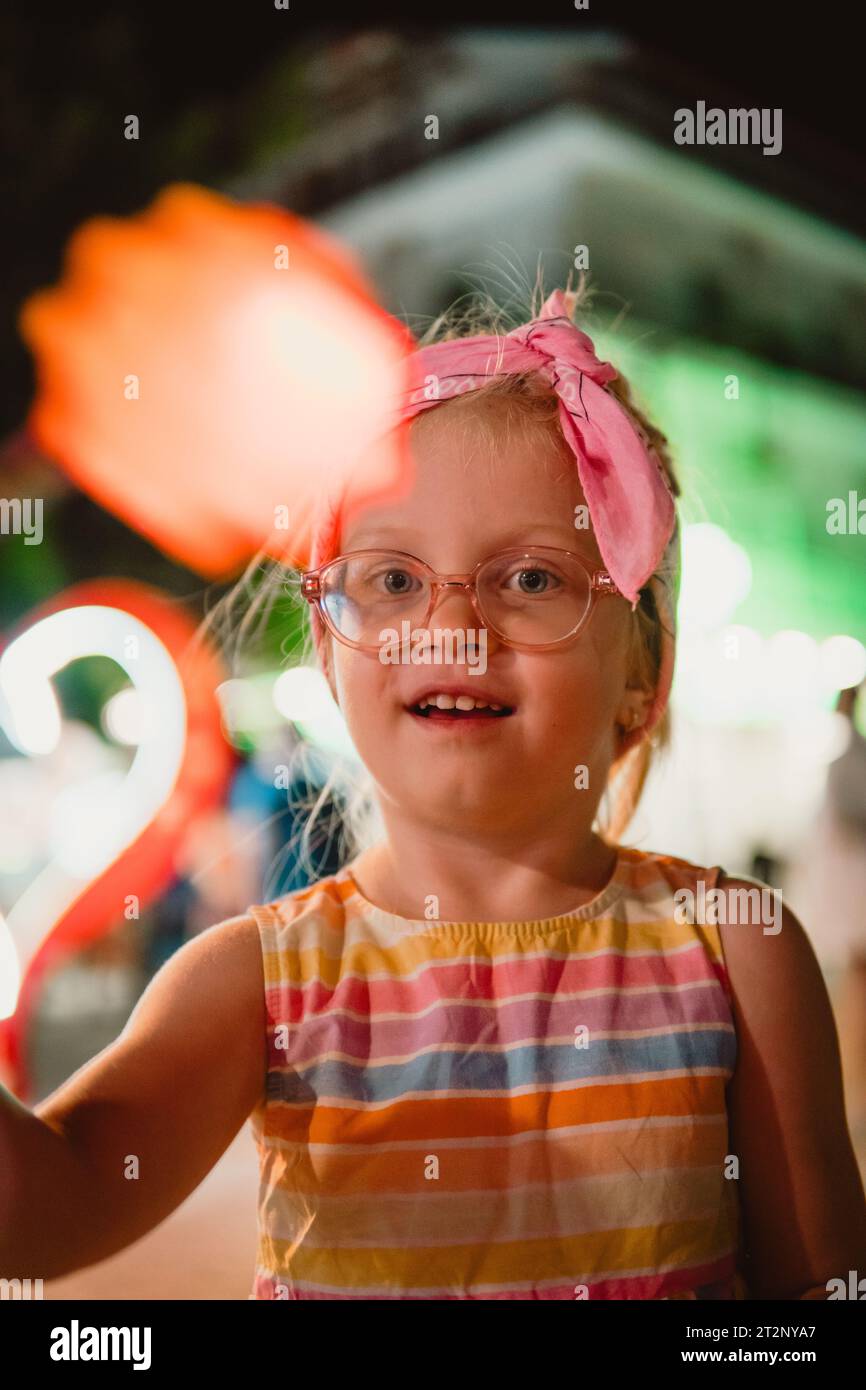 Petite fille jouant avec une balle colorée Banque D'Images