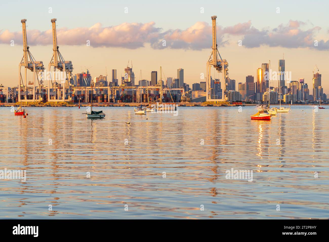 Vue sur une baie calme à bateaux et grues portiques du port de Melbourne à Victoria, Australie. Banque D'Images