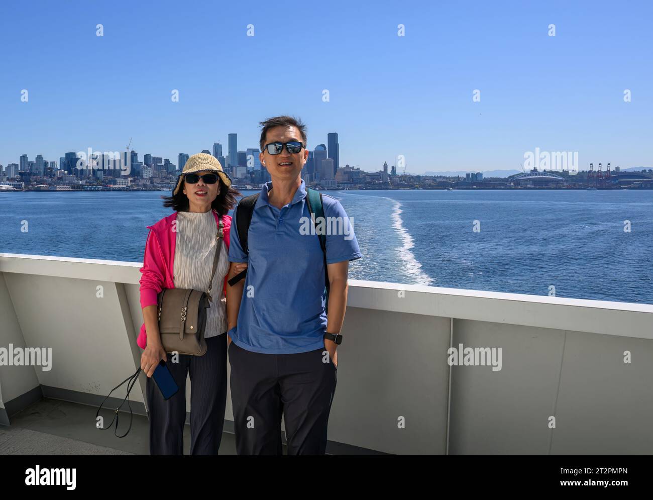 Touristes posant pour des téléphones sur le ferry à Elliott Bay. Seattle Skyline en arrière-plan. Seattle. État de Washington. Banque D'Images