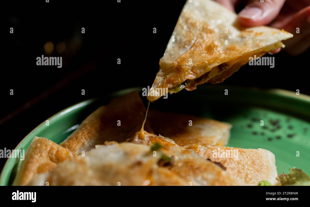 Italienne Mozzarella Pizza sur table noire, vue de dessus , main rapprochée et ordinateur portable pour le travail Banque D'Images