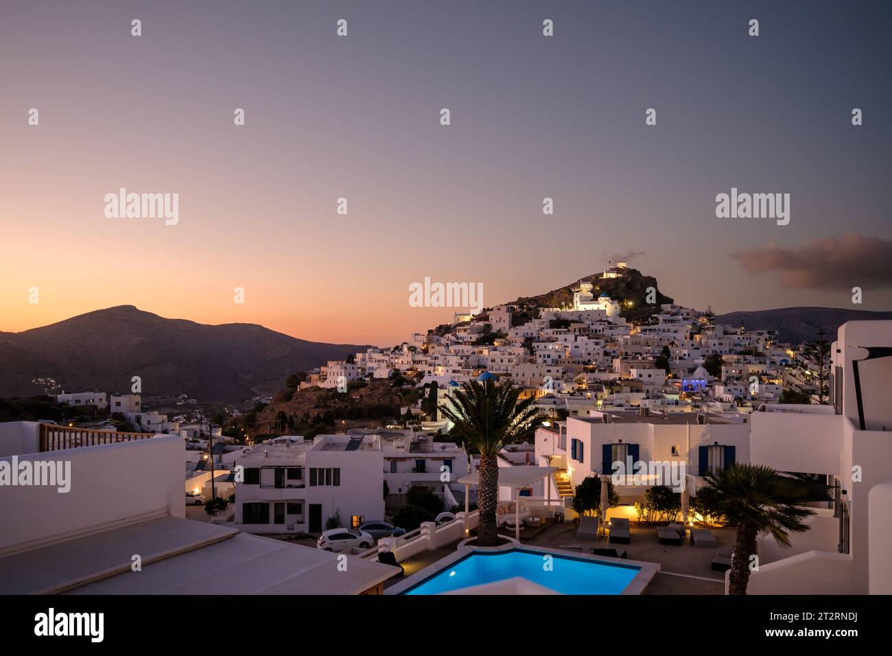 IOS, Grèce - 12 septembre 2023 : vue d'un hôtel pittoresque avec piscine et le village blanchi à la chaux d'iOS Grèce en arrière-plan Banque D'Images