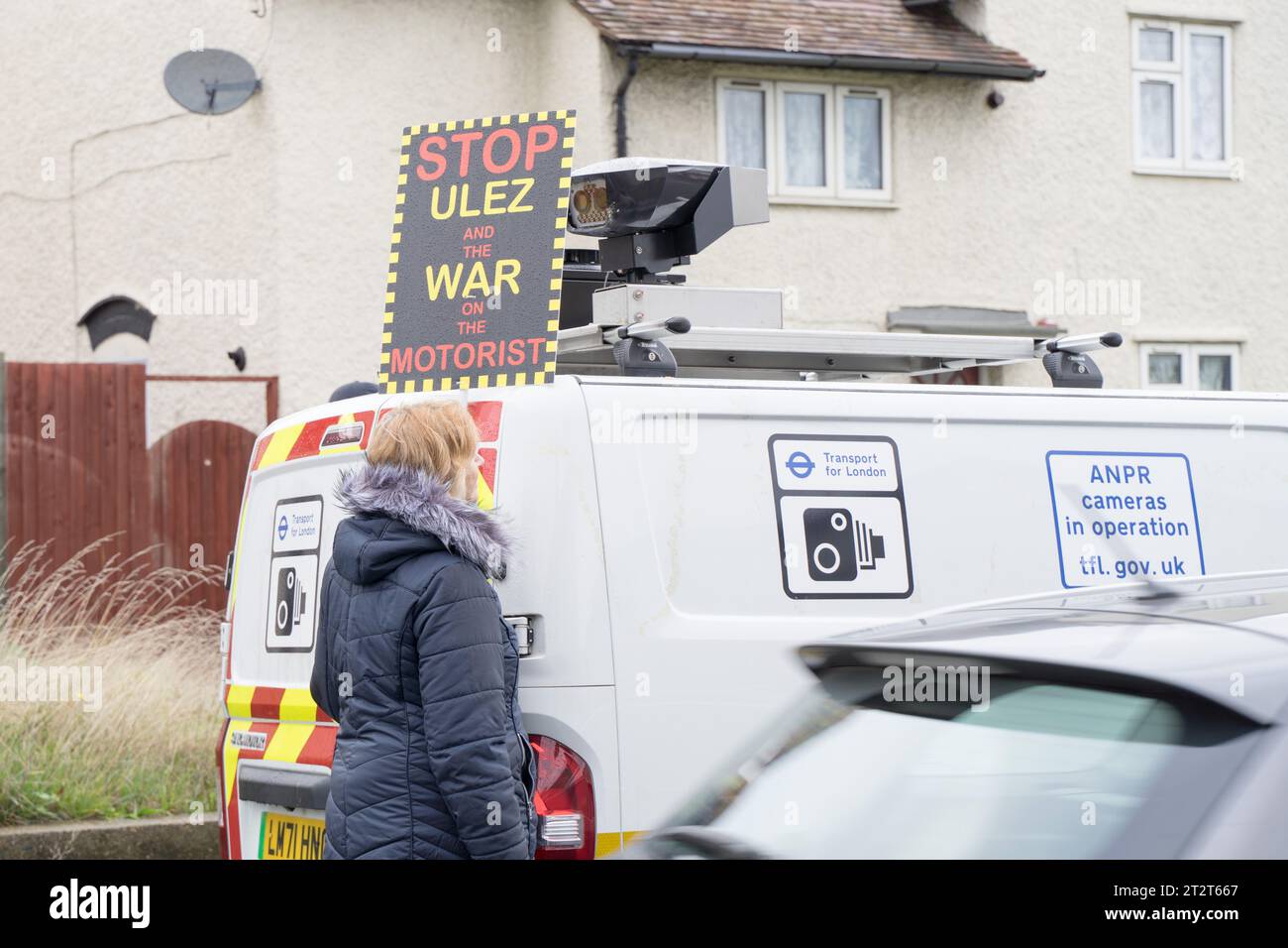 Greater London UK. 21 octobre 2023. Protecteur anti-ULEZ tenant une pancarte près d'un fourgon mobile ULEZ. Son fonctionnement près de Sidcup a été mis hors service en raison d'un pare-brise endommagé par une brique défaillante. Crédit : glosszoom/Alamy Live News Banque D'Images