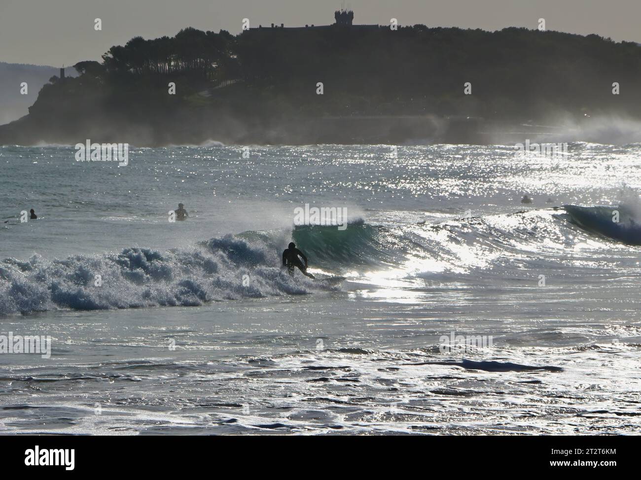 Paysage d'automne de la plage de Sardinero avec des surfeurs dans les vagues de 10 pieds et les embruns et la Magdalena Peninsular Sardinero Santander Cantabria Espagne Banque D'Images