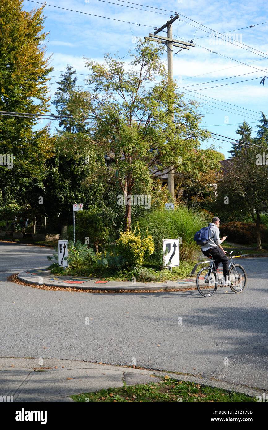 Cycliste passant par un rond-point résidentiel à East Vancouver Banque D'Images
