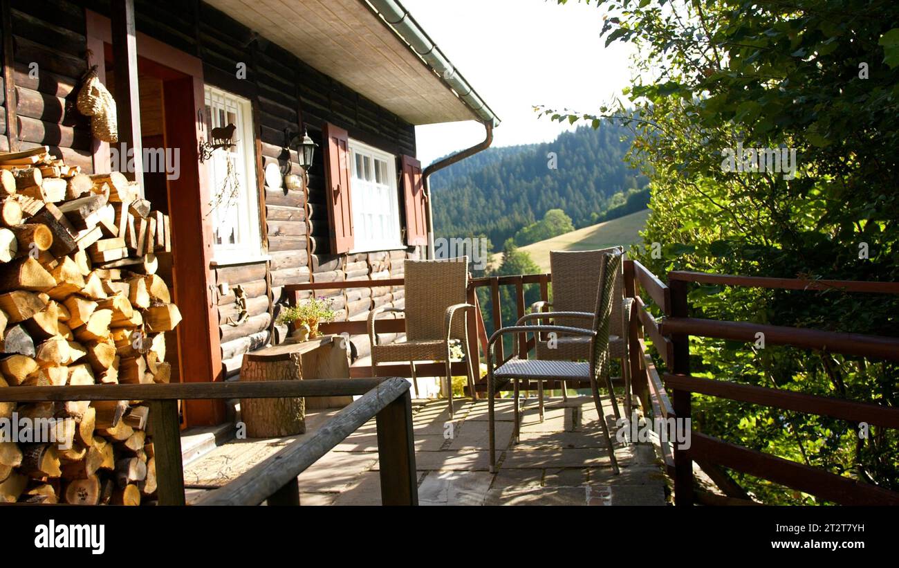 Une superbe cabane rustique avec un ensemble de meubles d'extérieur, y compris une table et des chaises Banque D'Images