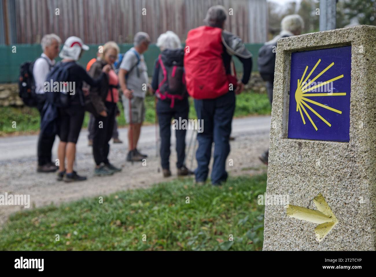 FONSAGRADA, 3 octobre 2023 : pèlerins sur le chemin de Saint-Jacques-de-Compostelle avec une borne de mille du Camino de Santiago Banque D'Images