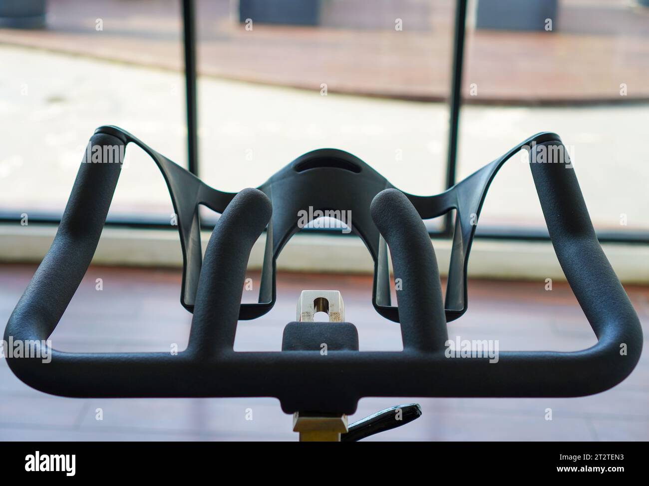 Gros plan d'un guidon de vélo statique en salle de gym. Vue détaillée des poignées de vélo d'appartement dans la salle de fitness Banque D'Images