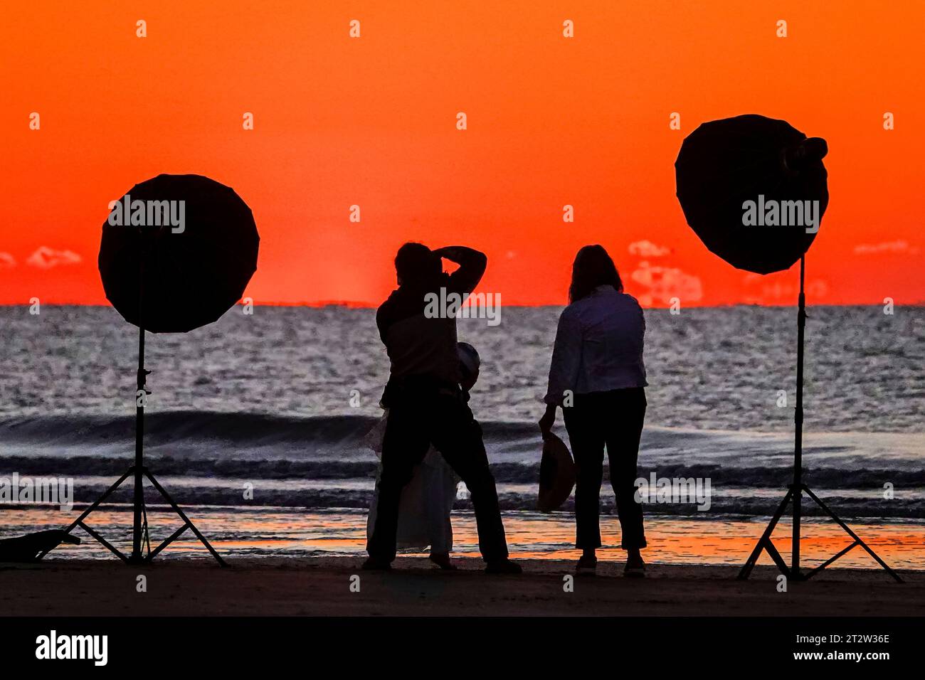 Île de Palms, États-Unis. 21 octobre 2023. Un photographe tient une séance photo découpée par le lever du soleil alors que le soleil se lève sur l'horizon de l'océan Atlantique depuis Front Beach, le 21 octobre 2023 à Isle of Palms, Caroline du Sud. Crédit : Richard Ellis/Richard Ellis/Alamy Live News Banque D'Images