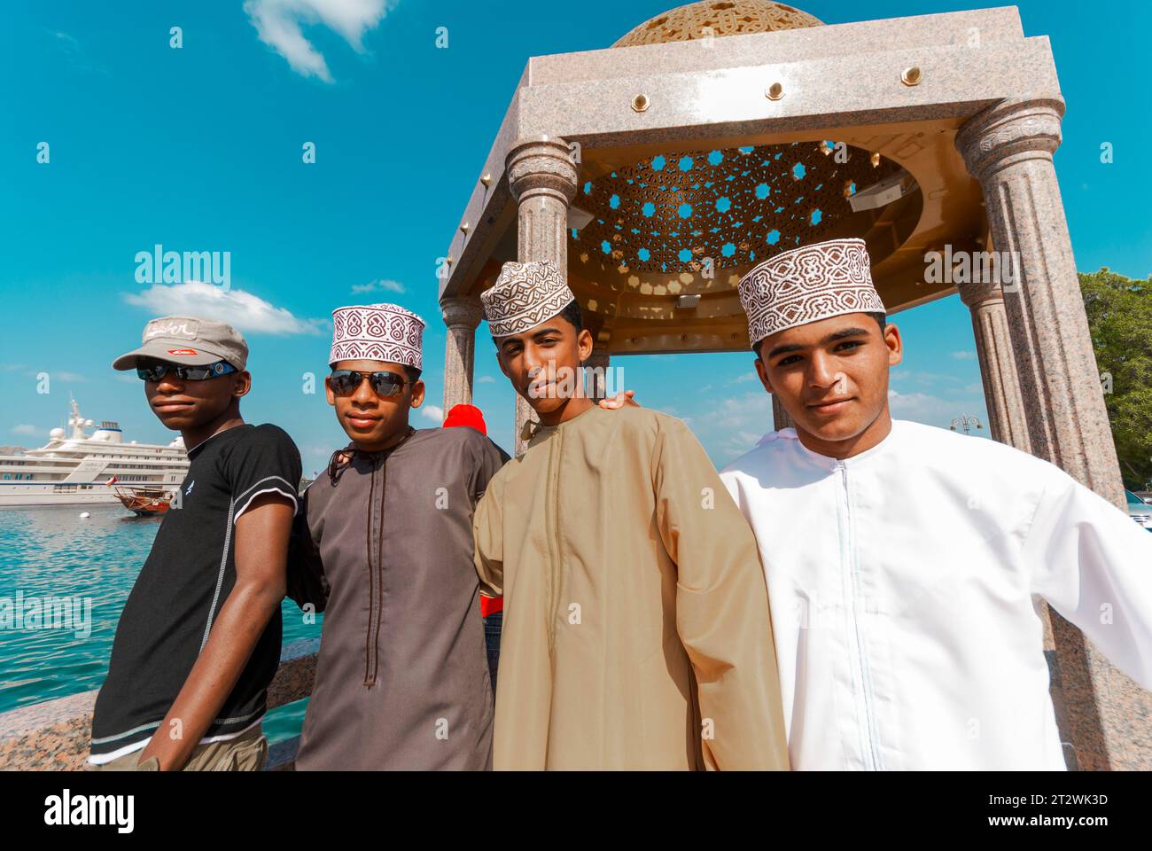 Joyeux local les jeunes hommes en vêtements traditionnels et occidentaux sourient pour la caméra à Mutrah Muscat à Oman Banque D'Images