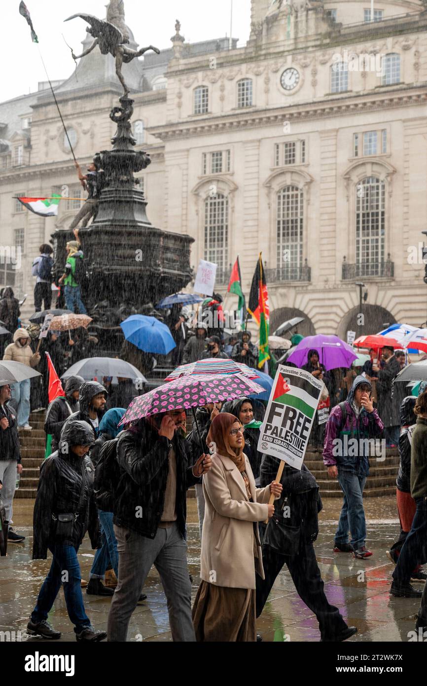 Les manifestants passent devant Eros à Londres avec des drapeaux palestiniens et une pancarte "Libérez la Palestine. Rassemblement contre le bombardement de Gaza. Londres. Octobre 2023. Banque D'Images