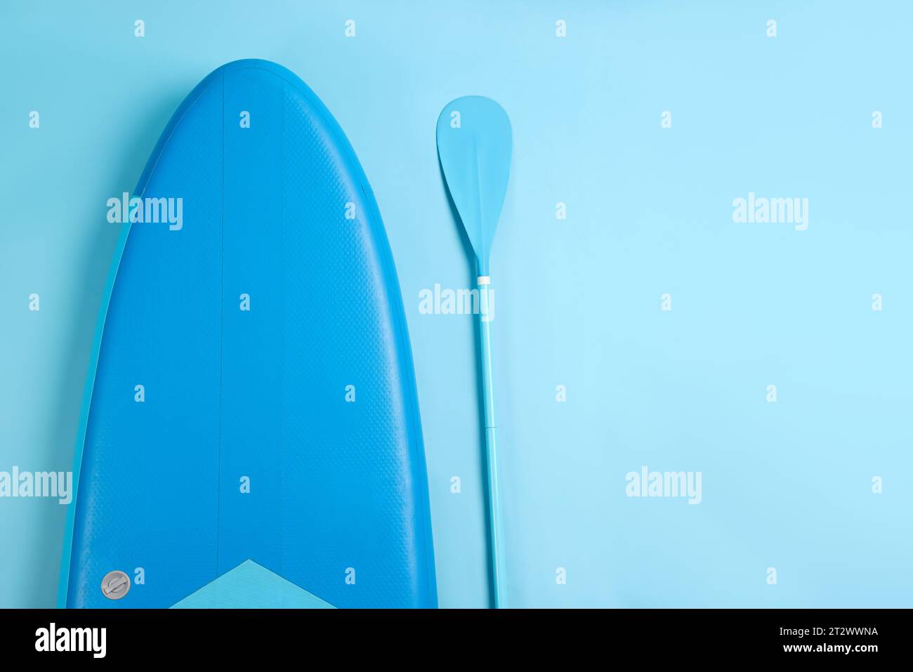 Planche et pagaie pour Standup paddleboard (SUP) sur fond bleu clair, pose à plat. Espace pour le texte Banque D'Images Planche et pagaie pour Standup paddleboard (SUP) sur fond bleu clair, pose à plat. Espace pour le texte Banque D'Images