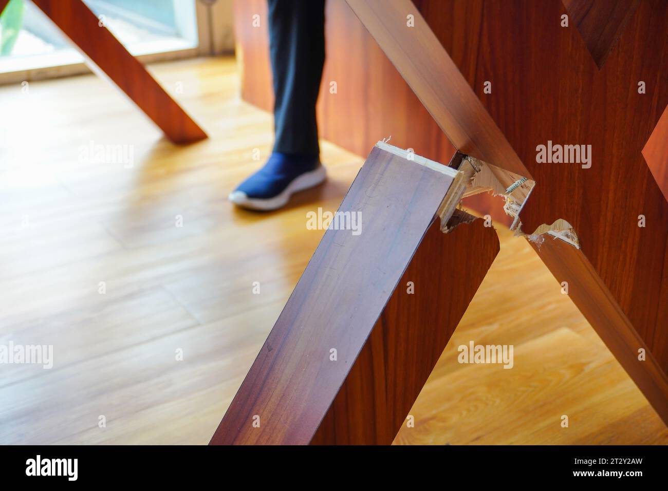 mettant en valeur un pied de table en bois cassé dans une mise au point sélective, sur le fond rustique d'une planche de chaise en bois Banque D'Images