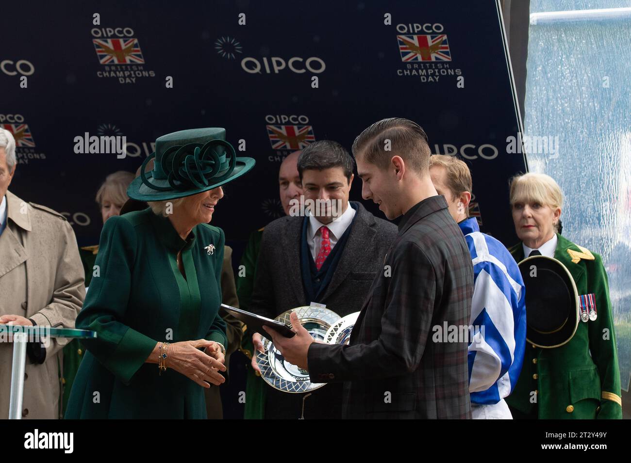 Ascot, Royaume-Uni. 21 octobre 2023. Queen Camilla a assisté à la QIPCO British Champions Day à l'hippodrome d'Ascot aujourd'hui. La reine Camilla portait un manteau de quart vert foncé et un chapeau assorti ainsi que des bottes en daim longueur genou. Elle portait également une broche en diamant avec un jockey monté sur un cheval dans les couleurs des soies royales du roi et de la reine. La Reine est photographiée en train de faire la présentation des Queen Elizabeth II Stakes au marié qui a été remporté par le jockey Aurelien Lemaitre sur le cheval Big Rock. Propriétaire Yeguada Centurion. Entraîneur Christopher Head, France. Éleveur Yeguada Centurioun SLU. Crédit : Maureen McLean/Alamy Live Banque D'Images