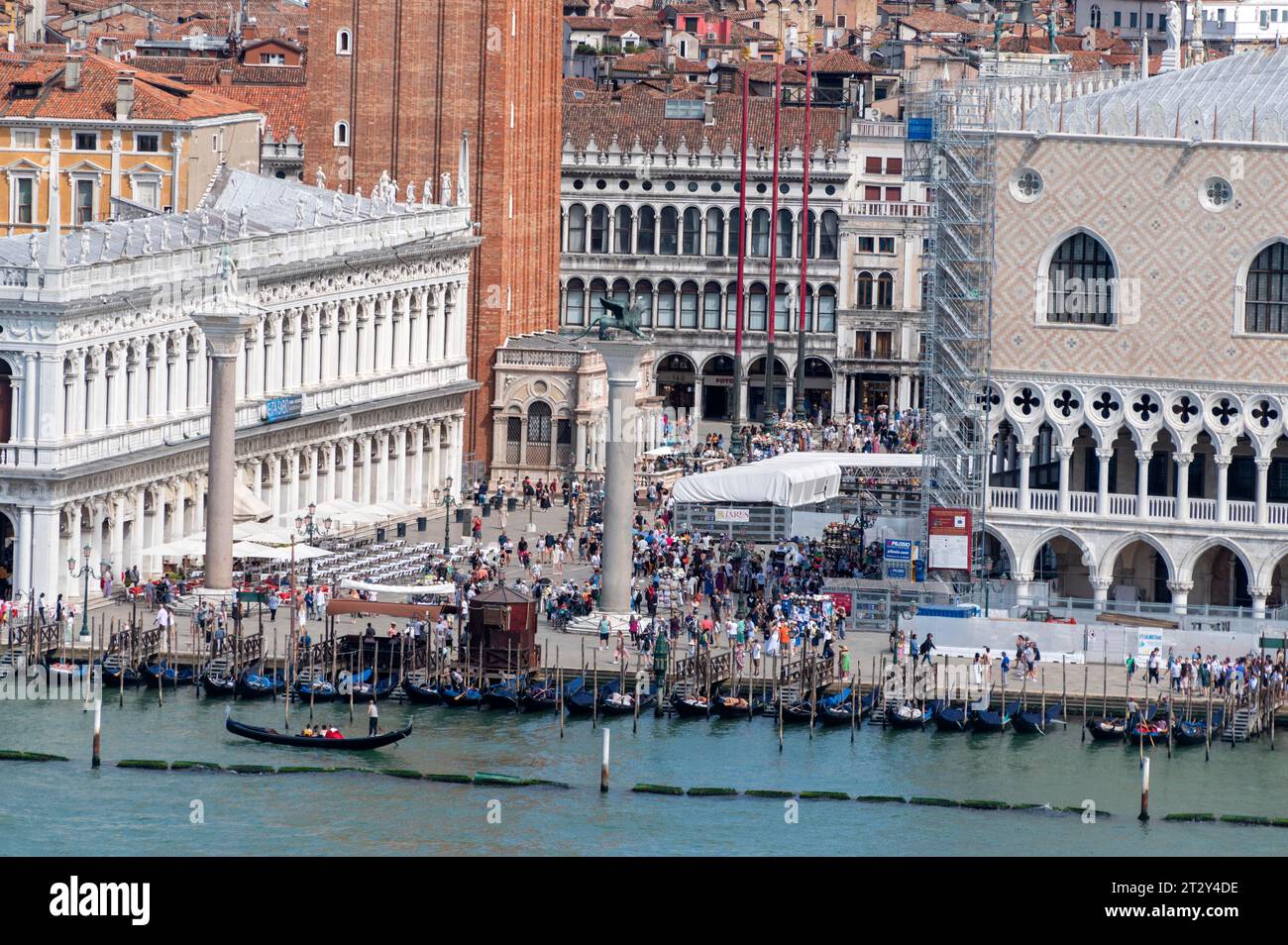 Les touristes remplissent la Piazza San Marco (place Saint-Marc) près du front de mer de la lagune de Venise dans la région de la Vénétie en Italie. (À gauche) est un seize Banque D'Images