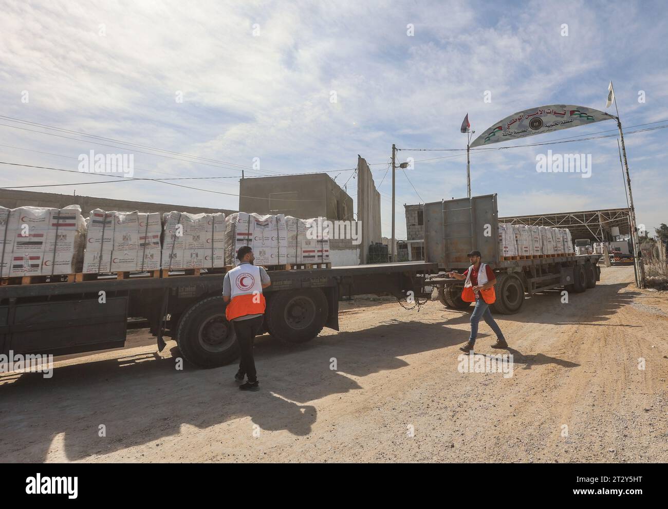 Gaza, Palestine. 21 octobre 2023. Des employés de la Société palestinienne du Croissant-Rouge reçoivent le convoi d'aide du côté égyptien, à la frontière de Rafah. L'agence des Nations Unies (ONU) devrait fournir une aide humanitaire à ceux qui en ont besoin dans diverses zones de la bande, a déclaré samedi le bureau des médias du gouvernement de Gaza. (Photo Ahmed Zakot/SOPA Images/Sipa USA) crédit : SIPA USA/Alamy Live News Banque D'Images