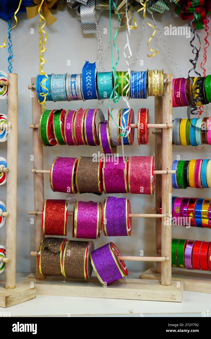 Collection de rubans cadeaux colorés : une gamme d'options vibrantes disposées sur un présentoir de magasin Banque D'Images