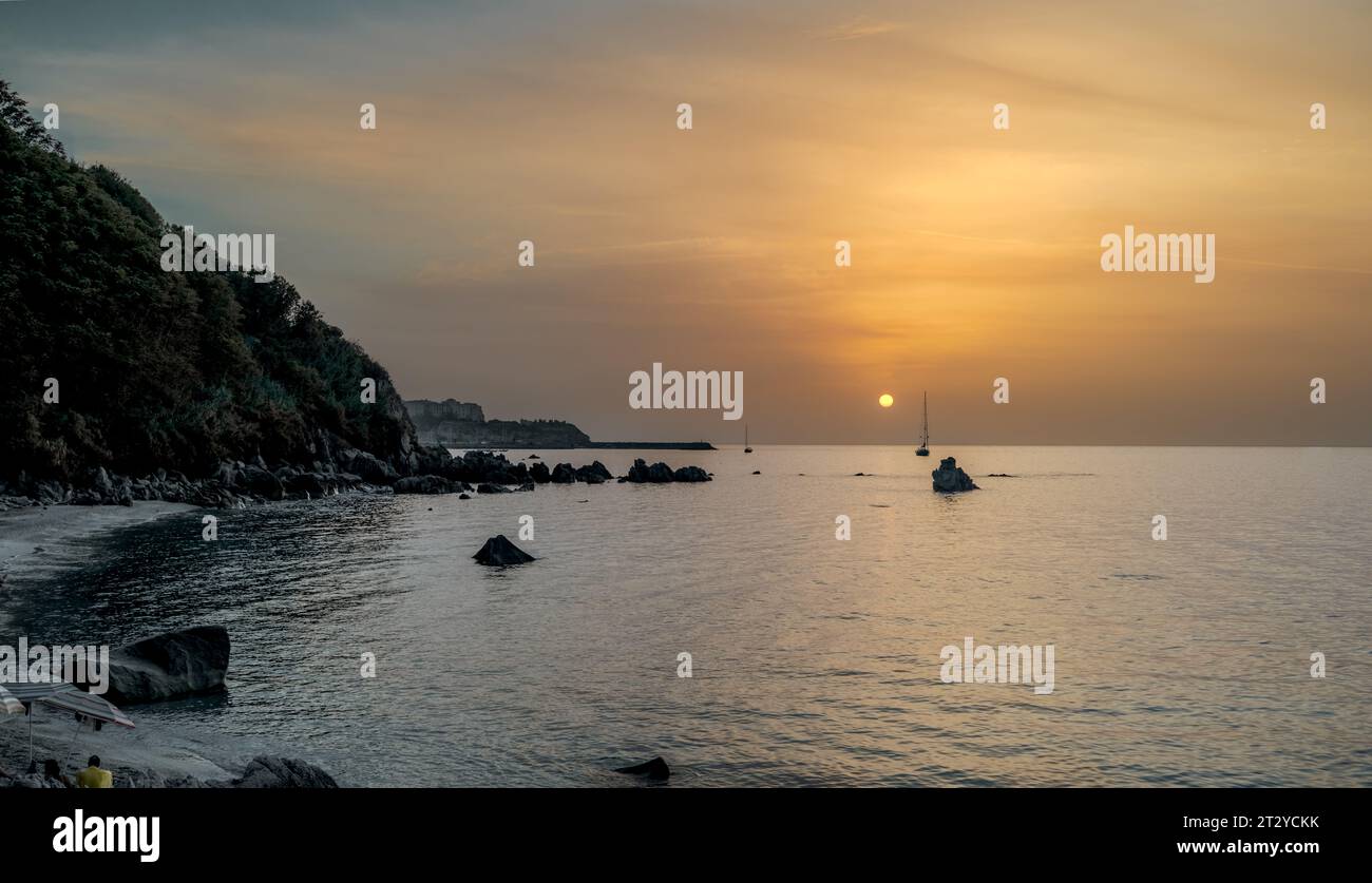 Coucher de soleil sur la célèbre plage de Michelino avec brume à l'horizon, Parghelia - Tropea, Vibo Valentia, Calabre, Italie Banque D'Images
