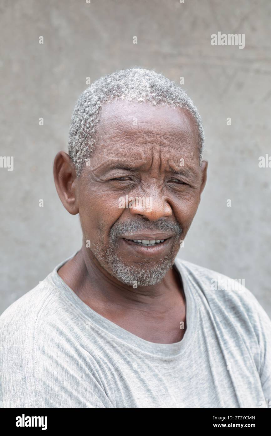 portrait de vieil homme africain contre le mur de sa maison dans le village Banque D'Images