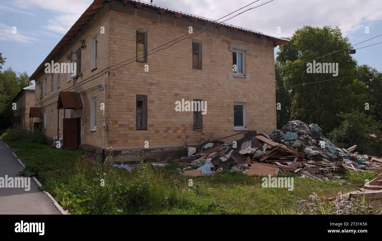 Maisons à deux étages. Clip. Petites maisons brisées debout dans les cours sur les rues vertes d'été et tirées contre le ciel. Banque D'Images