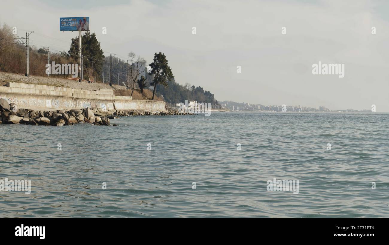 Paysage sur le remblai de la ville de la mer au printemps. Média. Belle vue apaisante sur l'eau et le remblai. Autoroute de remblai par la mer le jour nuageux Banque D'Images