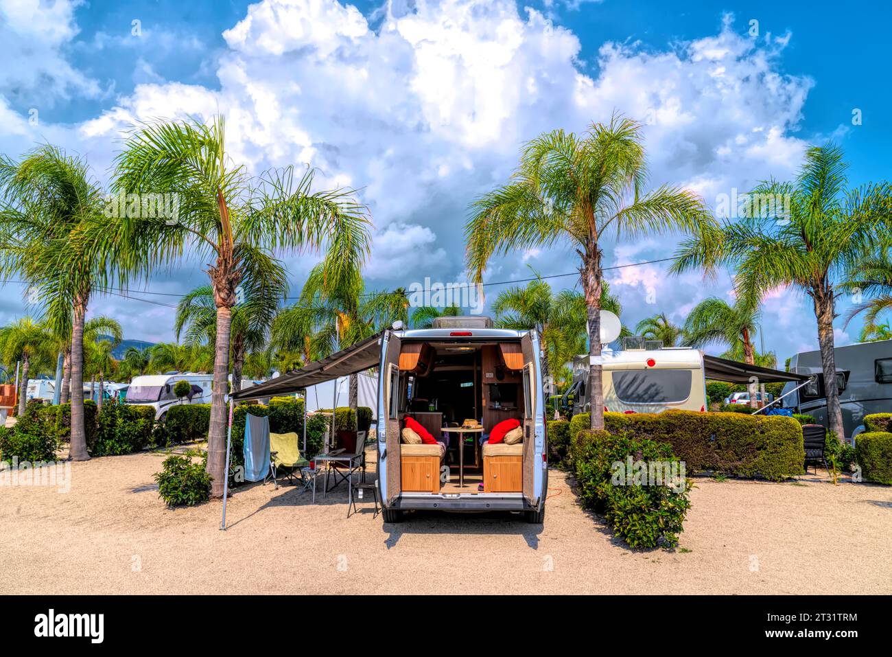 Campervan sur les palmiers tropicaux du camping et les portes dérobées s'ouvrent au soleil d'été Banque D'Images
