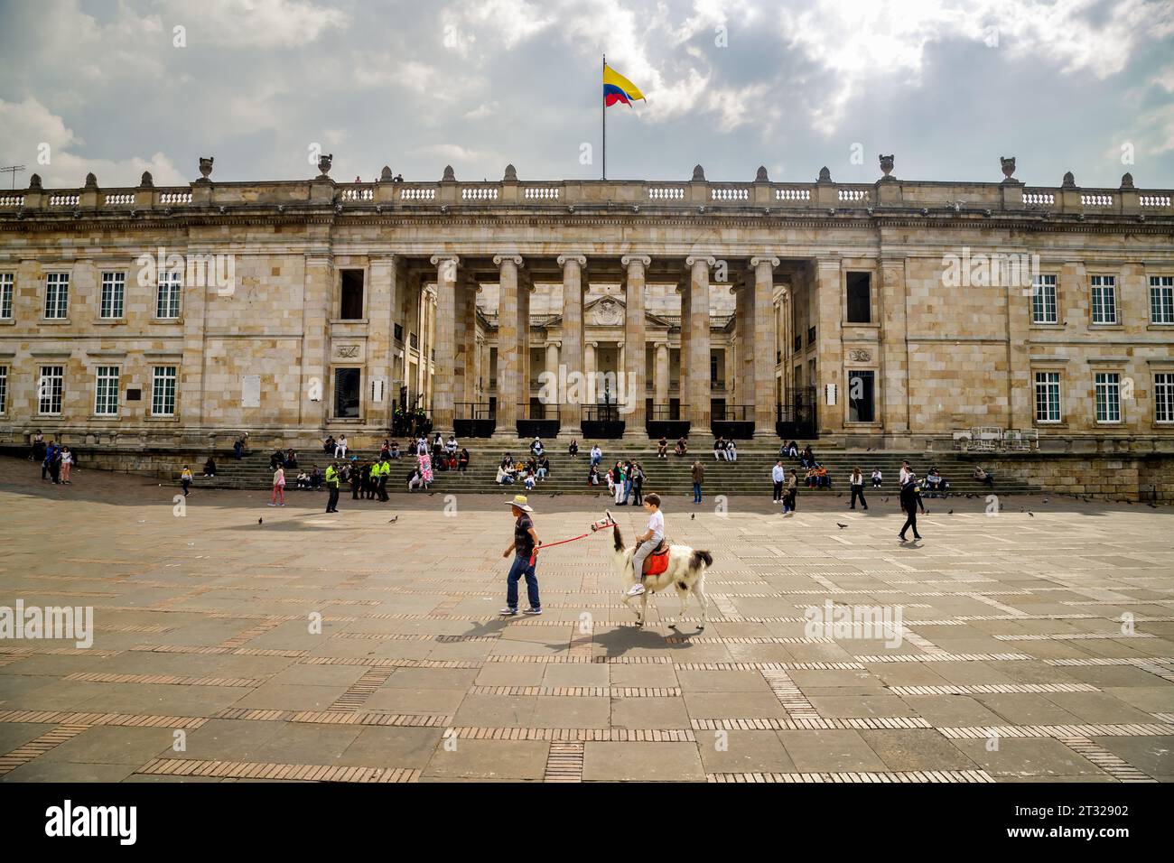 Bogota, Colombie - 1 janvier 2023 : un homme monte un enfant sur un lama à travers la Plaza Bolivar, la place principale de Bogota Banque D'Images