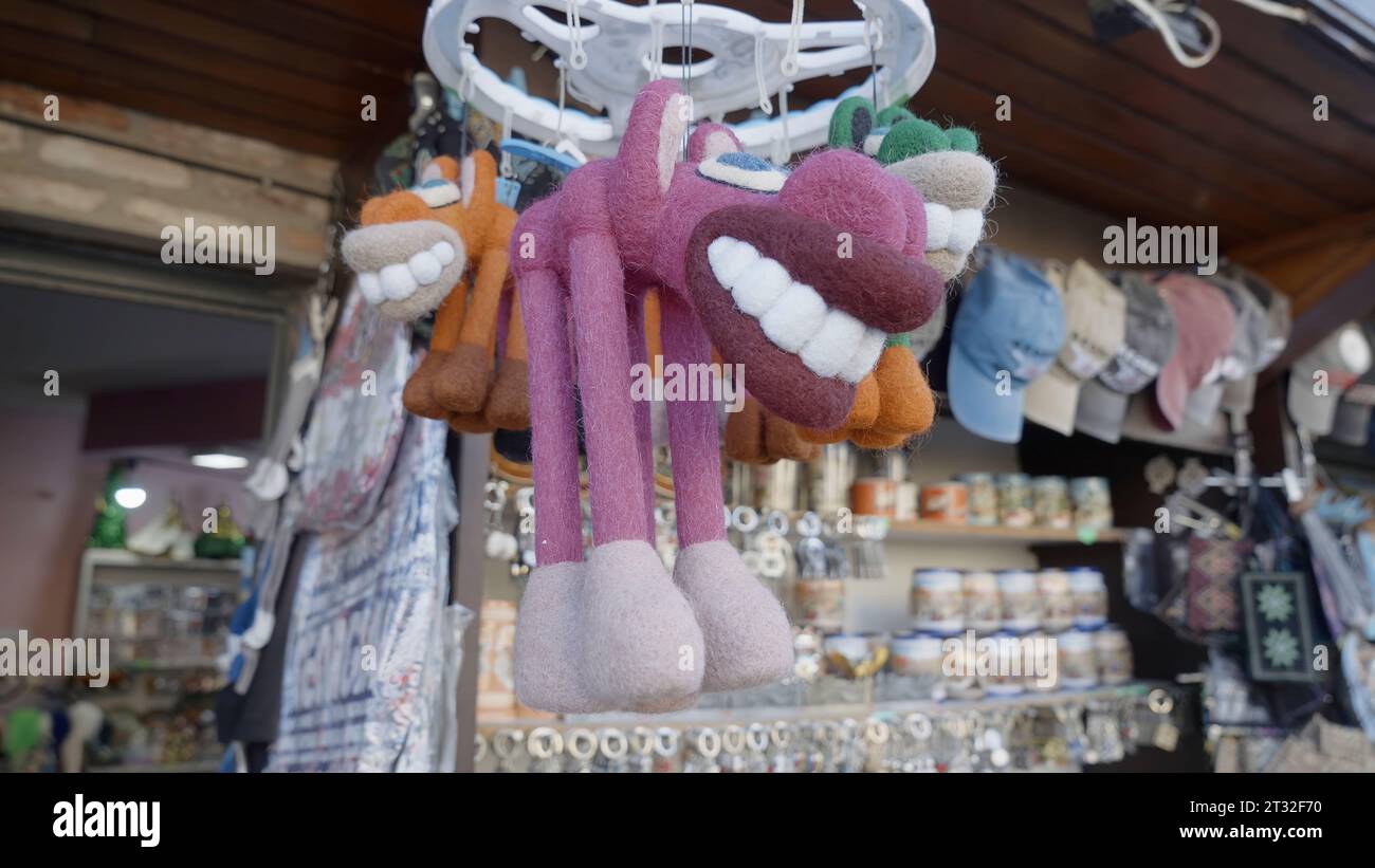 Un marché bon marché avec des souvenirs. Action. Produits affichés avec bouchons. avec de grosses dents de jouet, de la vaisselle et des chaînes porte-clés, prises d'un angle rapproché. Banque D'Images