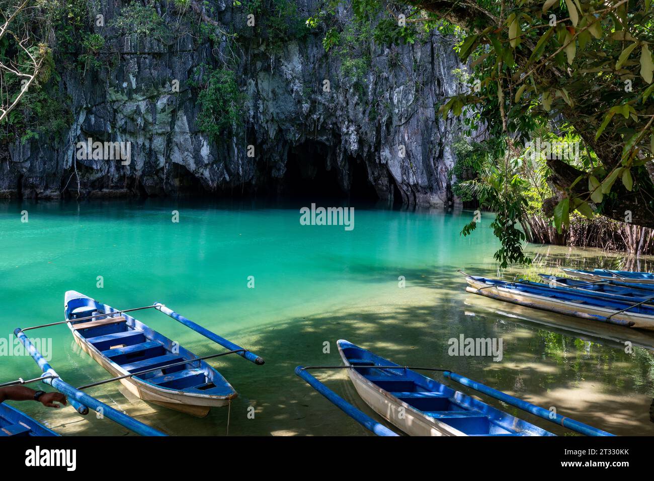 Site de bateaux bleus dans l'eau bleu vert en attente d'explorer le système souterrain de grottes et de cavernes de rivière Banque D'Images