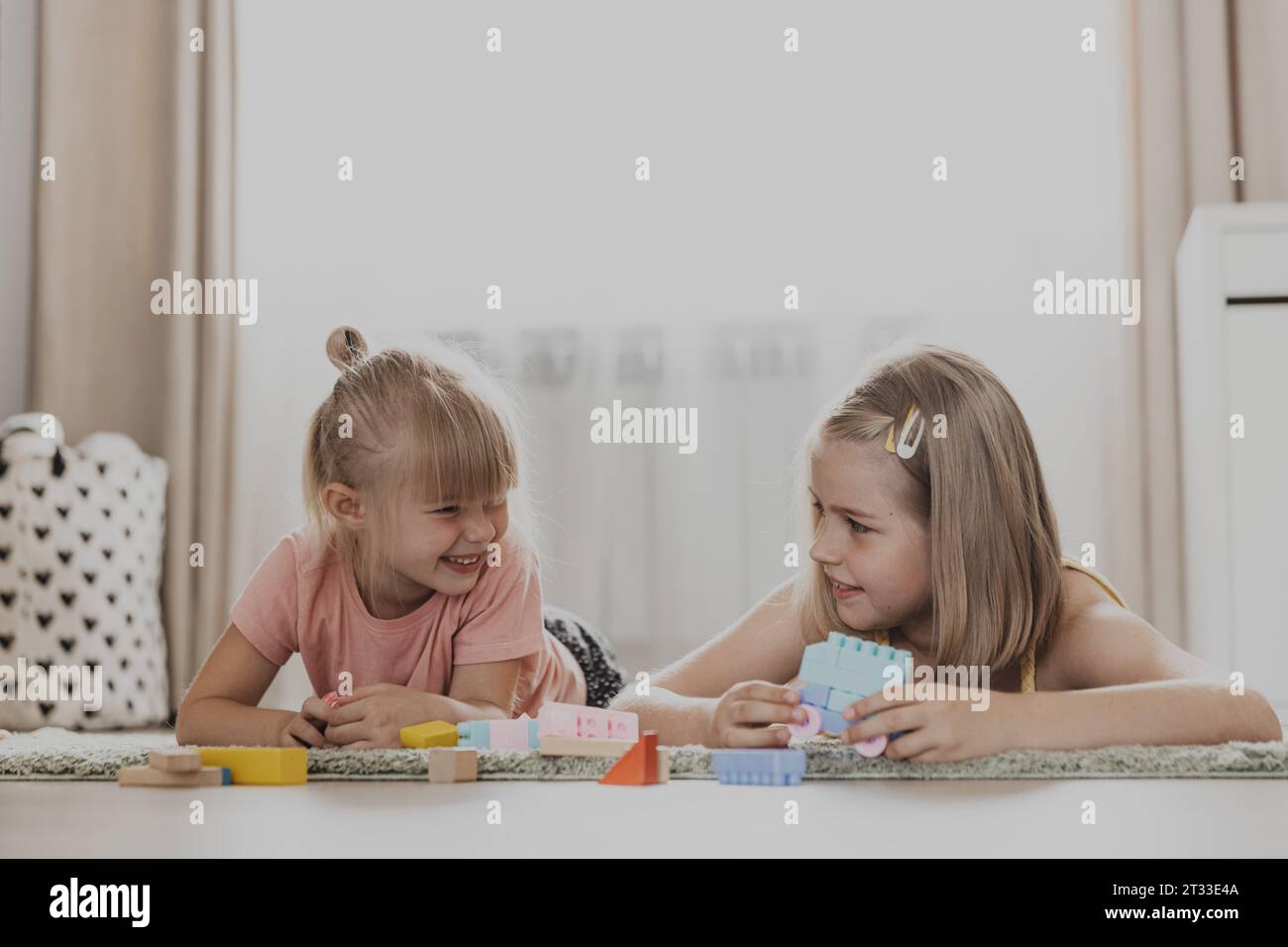 Enfants jouant avec des jouets colorés. Enfants assis sur la moquette à la chambre à coucher ou à la maternelle. Développement de la motricité fine, imagination, concept de pensée logique. Jeux écologiques éducatifs Banque D'Images