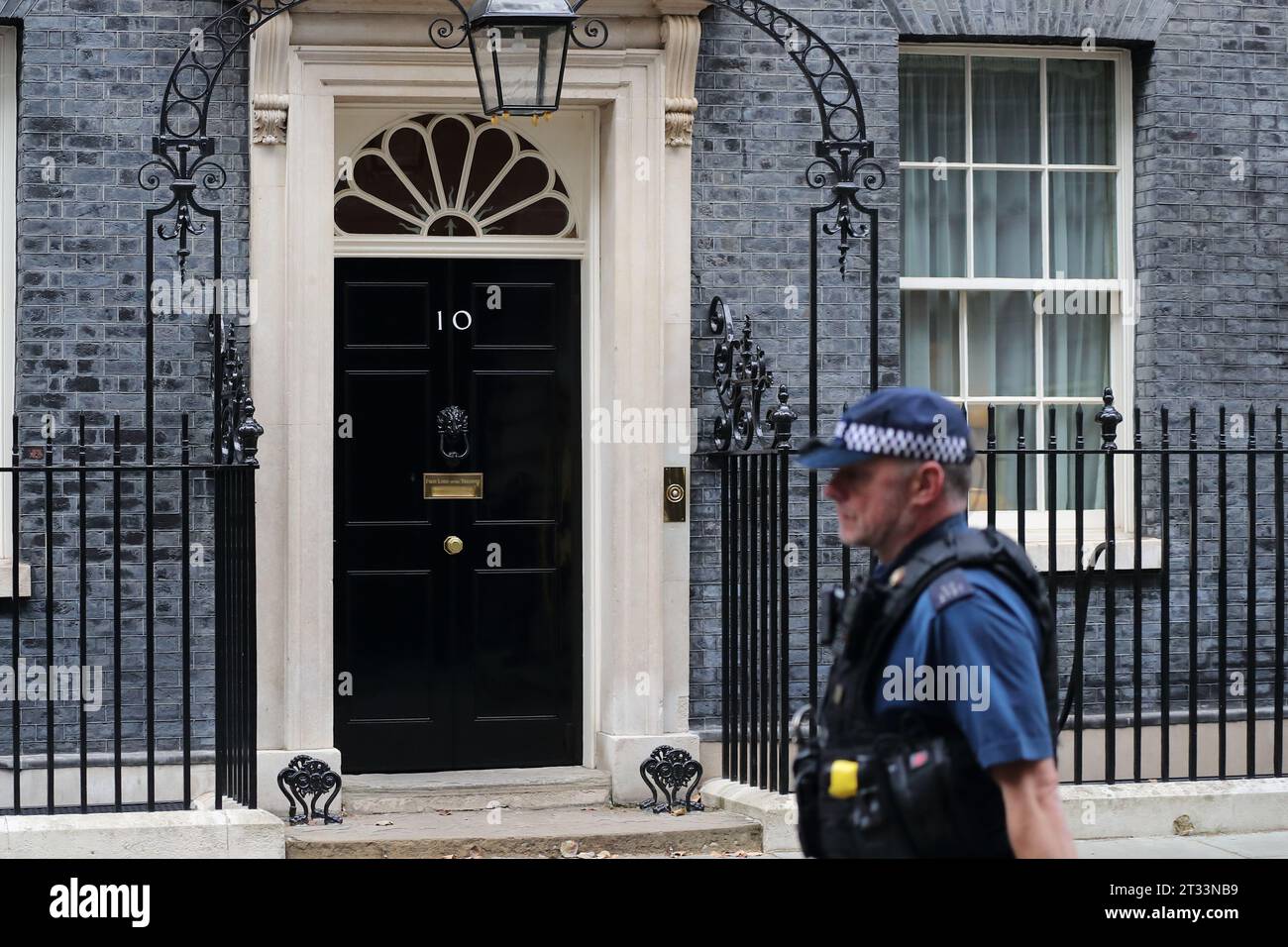 Un policier armé passe devant l'entrée du No 10 Downing Street, Londres, Royaume-Uni Banque D'Images