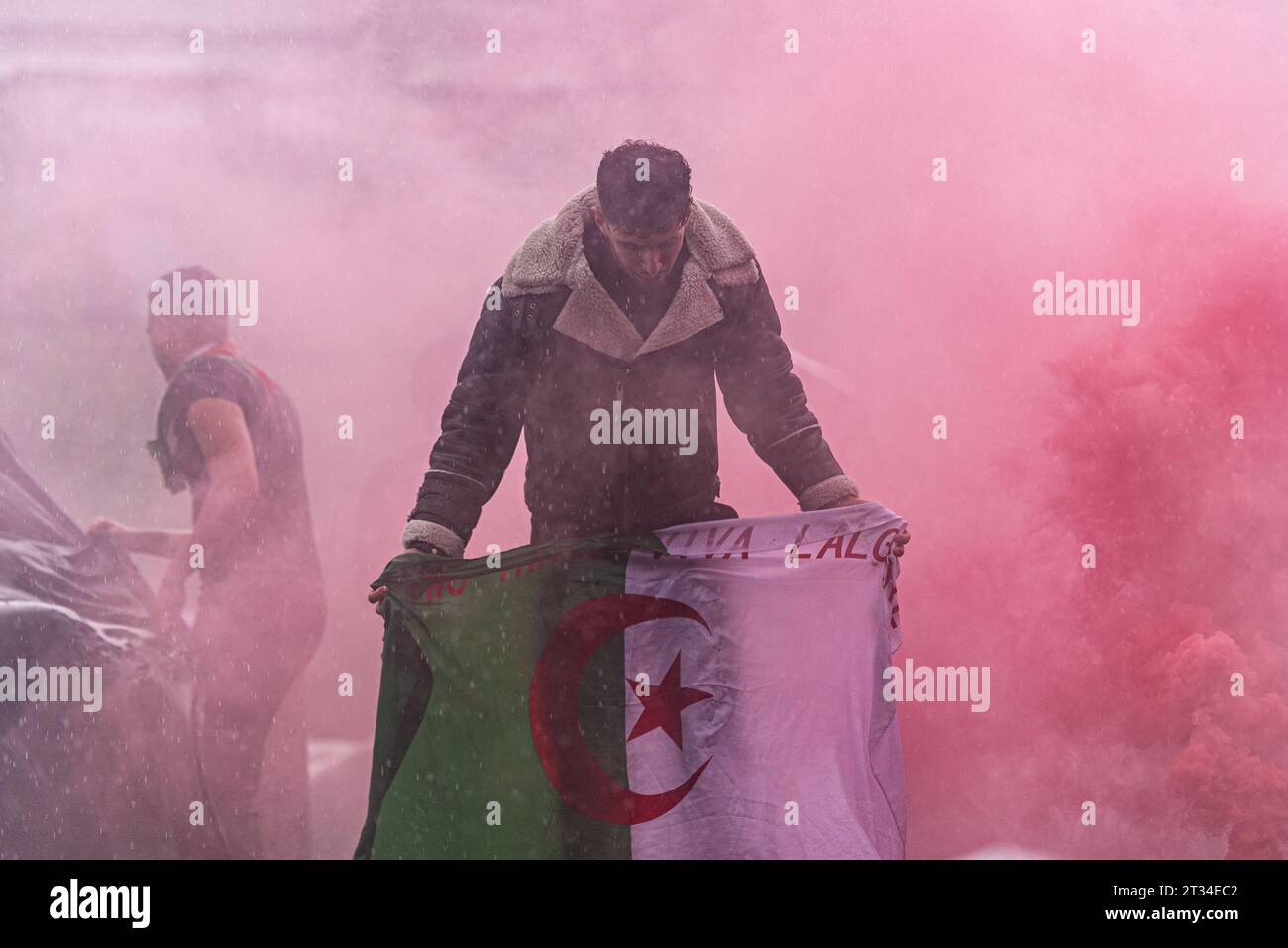 Un manifestant enveloppé de fumée rouge à Trafalgar SQ lors d'une manifestation en Palestine libre à Londres suite à l'escalade du conflit en Israël et à Gaza Banque D'Images
