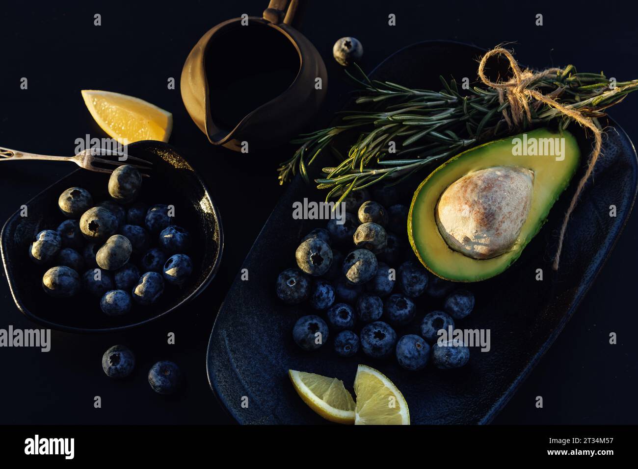Avocat et myrtille. Concept de nourriture végétalienne saine. Fond sombre, haut Banque D'Images