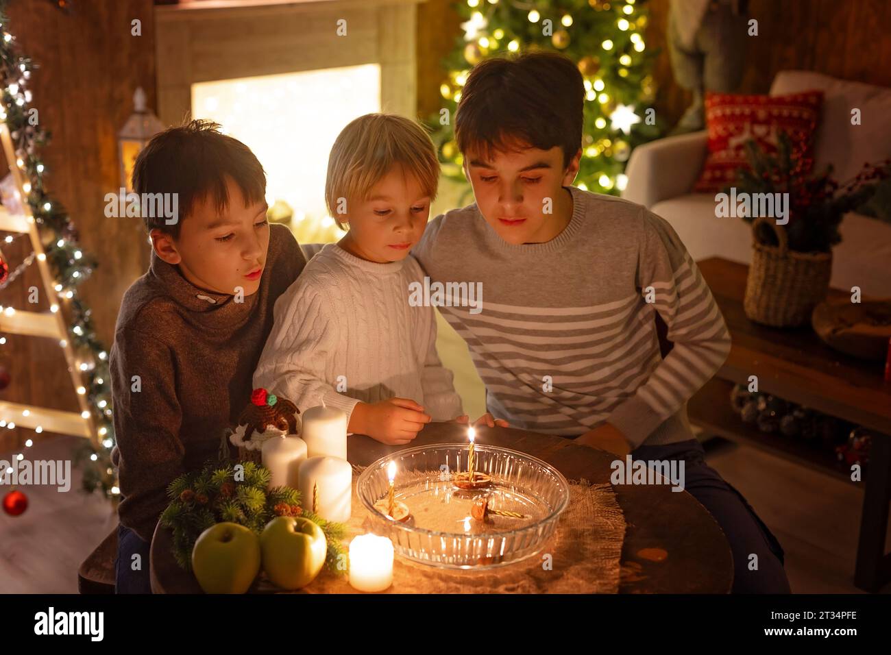 Trois enfants, allumant des bougies en un mot, traditions tchèques de Noël, salle décorée, traditions familiales Banque D'Images