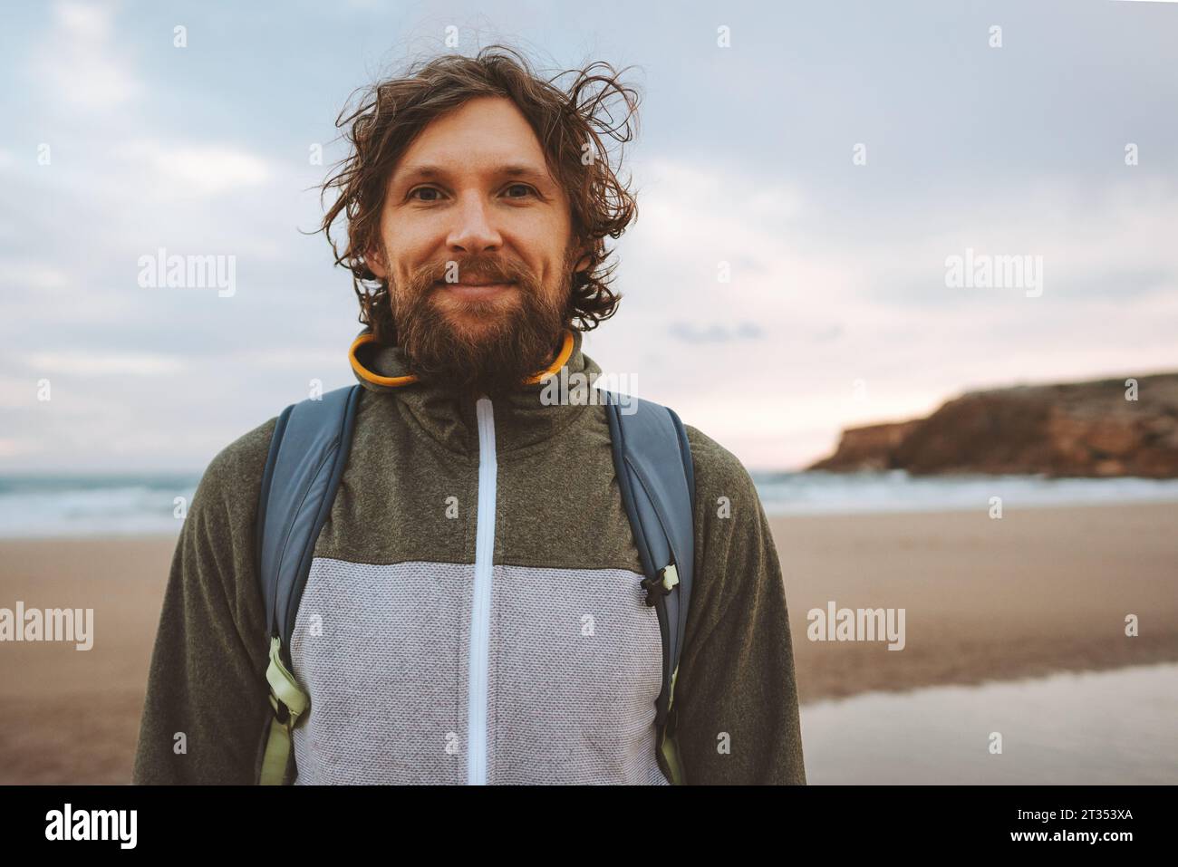 Bel homme portrait cheveux bouclés extérieur barbu gars avec sac à dos voyage style de vie vacances d'été actives Banque D'Images
