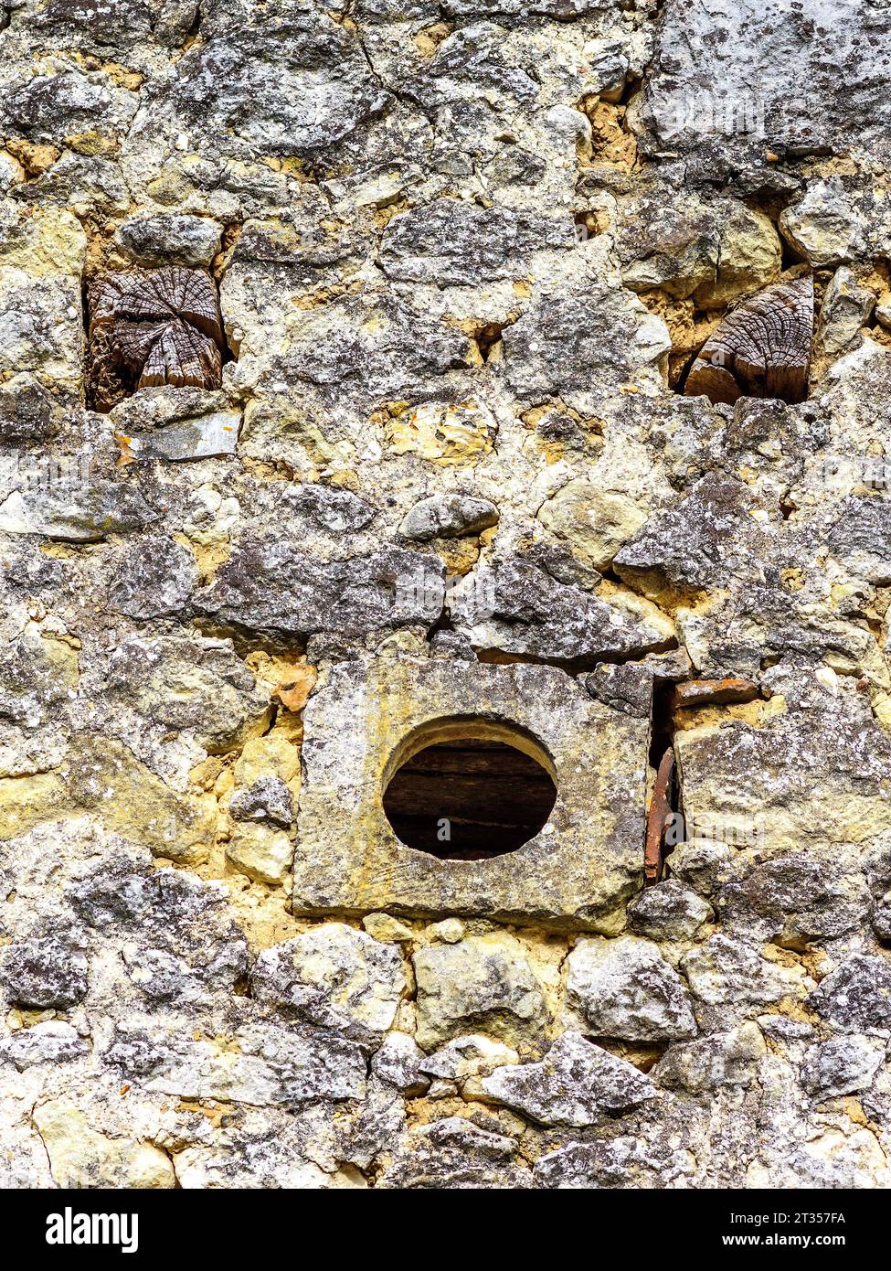 Petit trou de ventilation rond et extrémités de poutres en bois faisant un «visage drôle» dans
