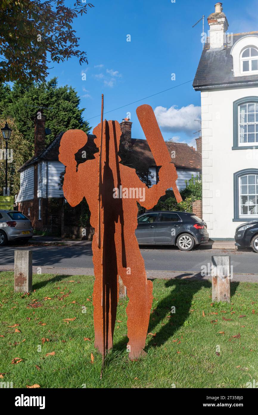 Godstone, Surrey, Angleterre, Royaume-Uni, le Mémorial de la première Guerre mondiale sur le vert du village, sculpture en acier comprenant deux personnages croisés, un soldat et un joueur de cricket Banque D'Images