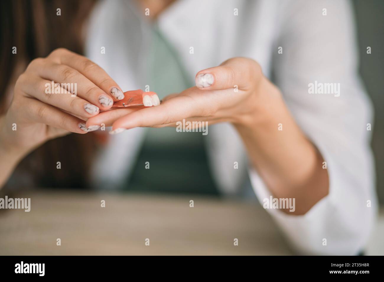 Prothèse dentaire d'enfant dans les mains du médecin gros plan. Photo conceptuelle dentaire. Dentisterie prothétique. Fausses dents Banque D'Images