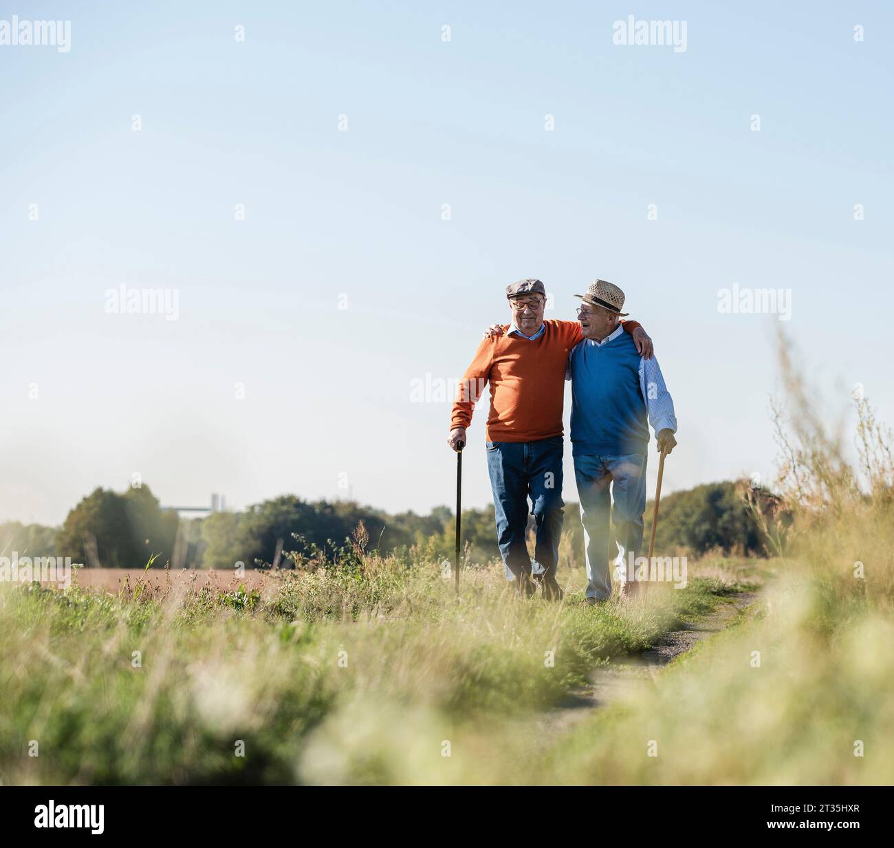 Deux vieux amis de prendre une promenade à travers les champs, en parlant de vieux temps Banque D'Images