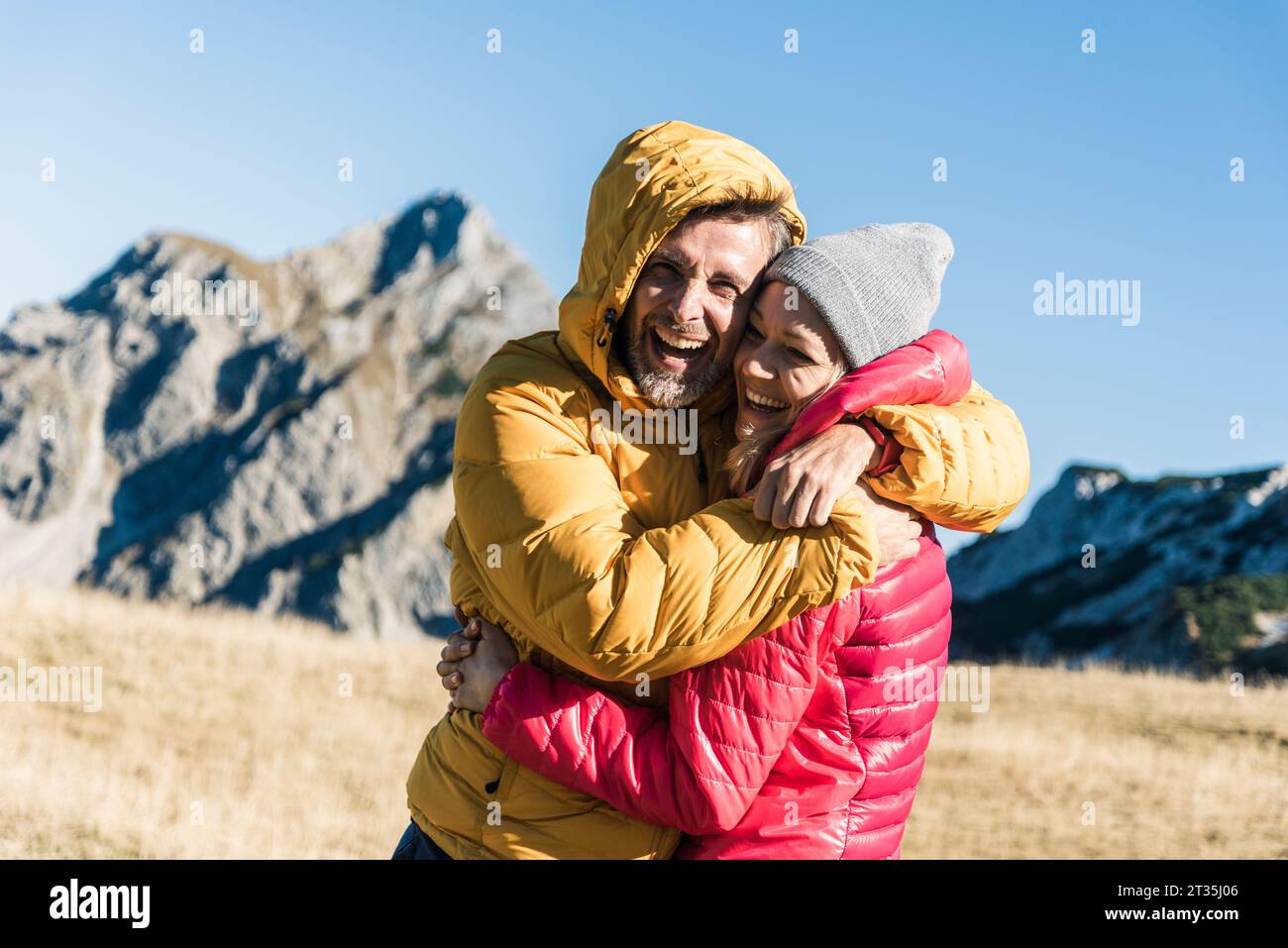 L'Autriche, le Tyrol, l'heureux couple hugging en randonnée dans les montagnes Banque D'Images