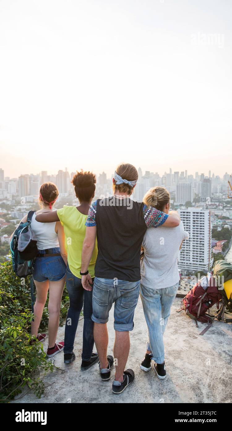 Amis profitant de la vue sur la ville depuis le toit au coucher du soleil Banque D'Images